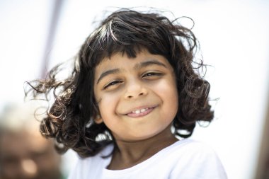 Khasab, Musandam - June 22, 2018: Outdoor portrait of little smiling pakistani girl clipart