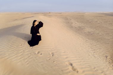 Dubai yakınındaki bir çölde abaya geleneksel kondominiyum giysili bir kadın aradı