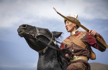 Göl: Issyk-Kul, Kurgyzstan, 6 Eylül 2018: bir yay ile genç göçebe ve ok ve doğada atlı