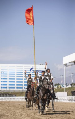 Göl: Issyk-Kul, Kyrgyzstan, 6 Eylül 2018: bir binicilik Kırgızistan bayrağı ile genç erkek hüner