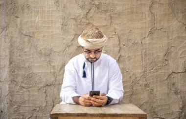 Arap adam eski Al Seef bölümünde Dubai, Suudi Arabistan, smartphone kullanarak