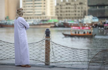 Arap adam eski Al Seef bölümünde Dubai, Suudi Arabistan, nehir kıyısında ayakta
