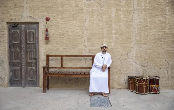 arab man sitting on bench in old Al Seef part of Dubai, United Arab Emirates