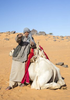 Meroe, Sudan 19 Aralık 2015: çöl gösteren onun deve ile mutlu sudan çocuk kameraya başparmak