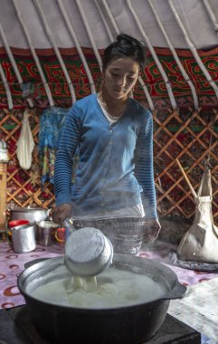 Bayan Olgii, Moğolistan, 29 Eylül 2015: Moğol kadın süt onun ev yurt içinde kaynar