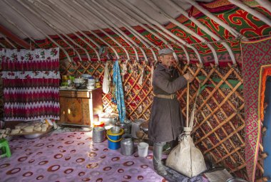 Bayan Olgii, Moğolistan - 29 Eylül 2015: Mongoilian kazak göçebe adam peynir yapımında yardım