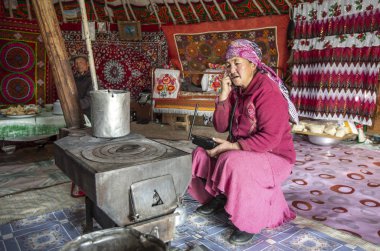 Bayan Olgii, Moğolistan - 29 Eylül 2015: Mongoilian kazak göçebe kadın onun ev yurt içinde telefonla söz