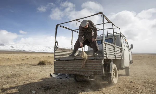 蒙古巴扬奥尔吉 2015年9月29日 蒙古哈萨克游牧民男子清洗汽车 准备将他们的蒙古包转移到新的地点 — 图库照片