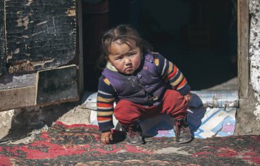 Bayan Ulgii, Moğolistan - 28 Eylül 2015: onu eve kapılarına at oynayan Moğol göçebe çocuk
