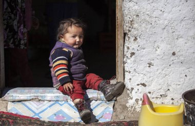 Bayan Ulgii, Moğolistan - 1 Ekim 2015: onu eve kapılarına at oynayan Moğol göçebe çocuk