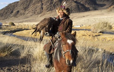 Bayan Ulgii, Moğolistan - 2 Ekim 2015: Kazak avcı geleneksel giyim atının üstünde kartal
