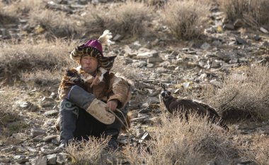Bayan Ulgii, Moğolistan-4 Ekim 2015: kazak kartal avcısı yerde rahatlatıcı
