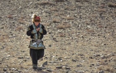 Bayan Ulgii, Moğolistan, 4 Ekim 2015: kayalık zemin üzerinde yürüyüş onun geleneksel kıyafeti kazak kartal avcı