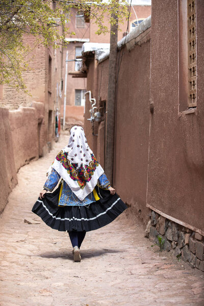 young beautiful Iranian lady in traditional clothing in village of Abyaneh