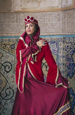 young beautiful Iranian lady dressed in red traditional dress in mosque in Kashan