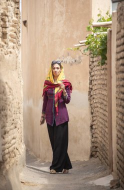 young beautiful Iranian lady on streets of old village in Iran