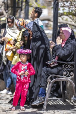 Niasar, İran - 25 Nisan 2019: Kalabalığın içinde başında çiçekler olan İranlı kız
