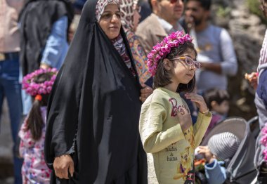 Niasar, İran - 25 Nisan 2019: Çiçekli İranlı genç kız, gül toplama mevsiminde yoldan geçenlere satıyor