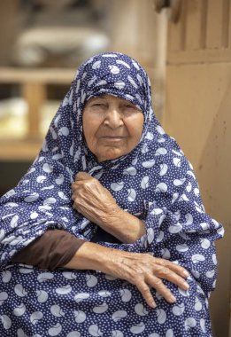 Keşan, İran - 25 Nisan 2019: İran'da köyünde kapısında dinlenen yaşlı İranlı kadın