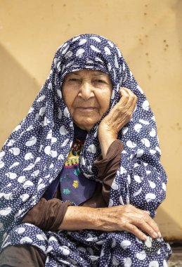 Keşan, İran - 25 Nisan 2019: İran'da köyünde kapısında dinlenen yaşlı İranlı kadın