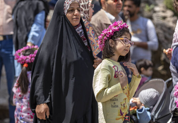 Niasar, Iran - 25th April, 2019: Iranian young girl with flowers, selling them to passersby during rose picking season