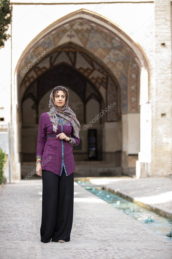 young beautiful iranian lady walking in Fin Gardens in Kashan, Iran
