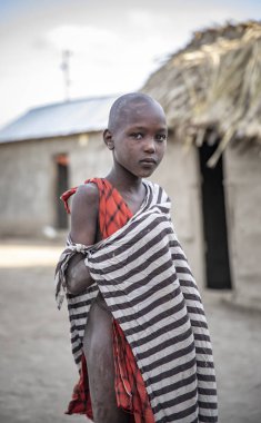 Same, Tanzanya-7 Haziran, 2019: onun Boma genç Maasai çocuk, arka planda evi ile