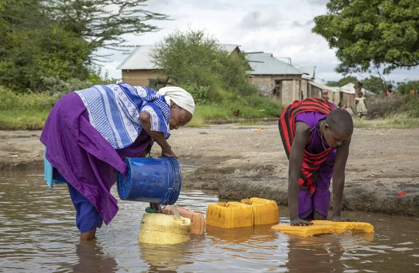 Aynı, Tanzanya, 8 Haziran 2019: Maasai kadınlar çamurlu derede içme suyu topluyor