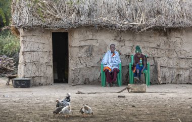 Aynı, Tanzanya, 5 Haziran, 2019: Maasai çift evlerinin önünde dinleniyor