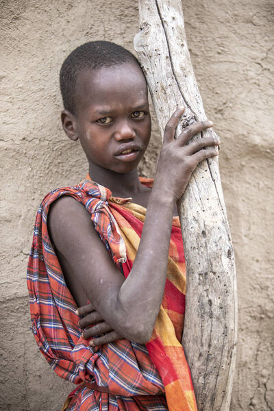 То же самое, Танзания, 5 июня 2019 года: молодой Масаи перед своим домом
