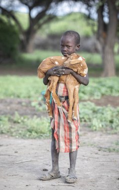 Aynı, Tanzanya - 4 Haziran 2019: bebek keçi ile maasai çocuk
