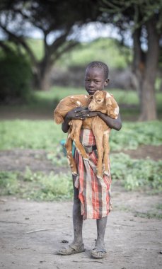 Aynı, Tanzanya - 4 Haziran 2019: bebek keçi ile maasai çocuk