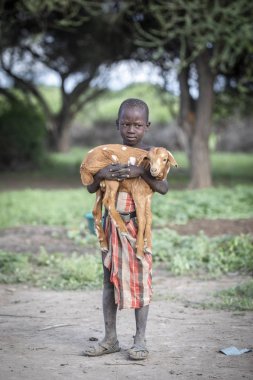 Aynı, Tanzanya - 4 Haziran 2019: bebek keçi ile maasai çocuk