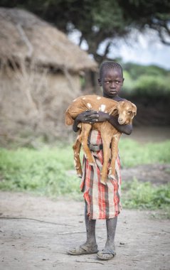 Aynı, Tanzanya - 4 Haziran 2019: bebek keçi ile maasai çocuk