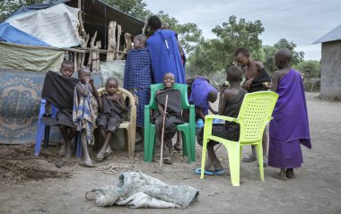 Aynı, Tanzanya - 4 Haziran 2019: Siyah giyinmiş Maasai erkekleri, onları hayatlarının bir sonraki aşamasına götüren 'geçiş hakkı' seremonisine hazır. Ertesi sabah sünnet edildiler ve maasai savaşçısı oldular.