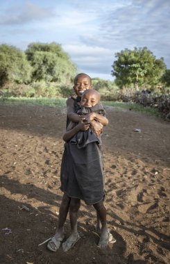 Aynı, Tanzanya - 4 Haziran 2019: Siyah giyinmiş Maasai erkekleri, onları hayatlarının bir sonraki aşamasına götüren 'geçiş hakkı' seremonisine hazır. Ertesi sabah sünnet edildiler ve maasai savaşçısı oldular.
