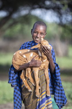 Aynı, Tanzanya - 4 Haziran 2019: bir bebek keçi ile maasai çocuk