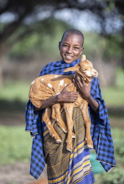Aynı, Tanzanya - 4 Haziran 2019: bir bebek keçi ile maasai çocuk