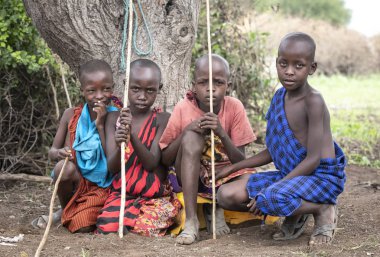 Aynı, Tanzanya - 5 Haziran 2019: ağaç altında dinlenen genç maasai erkek
