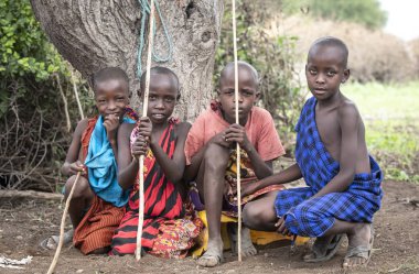 Aynı, Tanzanya - 5 Haziran 2019: ağaç altında dinlenen genç maasai erkek