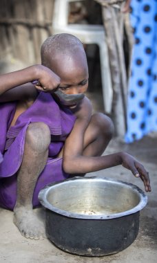 Aynı, Tanzanya - 4 Haziran 2019: genç Maasai kız o daha fazla yiyebilirsiniz böylece pot artıkları kazıma