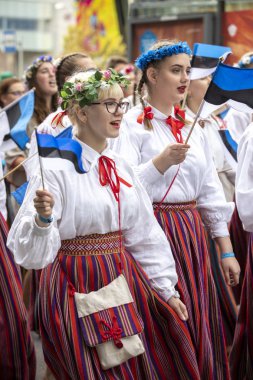 Tallinn, Estonya - 6 Temmuz 2019: Tallinn sokaklarında geleneksel giyimli kız öğrenciler