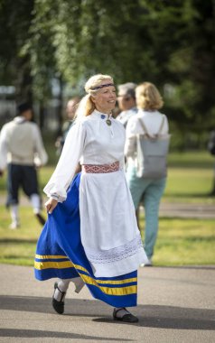 Tallinn, Estonya, 6 Temmuz 2019: Tallinn'de her 5 yılda bir düzenlenen 'laulupide' şarkı festivali sırasında Pirita'daki şarkı festivali nde geleneksel estonya giyimli kadın