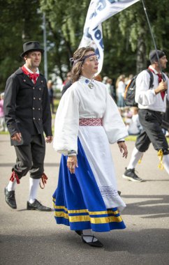 Tallinn, Estonya, 6 Temmuz 2019: Tallinn'de her 5 yılda bir düzenlenen 'laulupide' şarkı festivali sırasında Pirita'daki şarkı festivali nde geleneksel estonya kıyafetleri içinde insanlar
