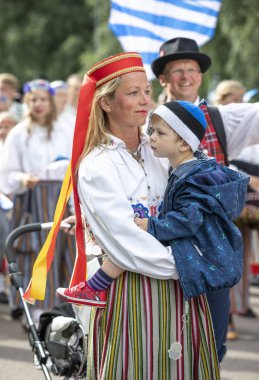 Tallinn, Estonya, 6 Temmuz 2019: Tallinn'de her 5 yılda bir düzenlenen 'laulupide' şarkı festivali sırasında Pirita'daki şarkı festivali nde geleneksel estonya kıyafetleri içinde insanlar