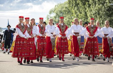Tallinn, Estonya, 6 Temmuz 2019: Tallinn'de her 5 yılda bir düzenlenen 'laulupide' şarkı festivali sırasında Pirita'daki şarkı festivali nde geleneksel estonya kıyafetleri içinde insanlar