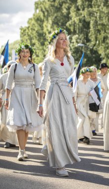 Tallinn, Estonya, 6 Temmuz 2019: Tallinn'de her 5 yılda bir düzenlenen 'laulupide' şarkı festivali sırasında Pirita'daki şarkı festivali nde geleneksel estonya kıyafetleri içinde insanlar
