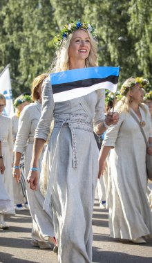 Tallinn, Estonya, 6 Temmuz 2019: Tallinn'de her 5 yılda bir düzenlenen 'laulupide' şarkı festivali sırasında Pirita'daki şarkı festivali nde geleneksel estonya kıyafetleri içinde insanlar