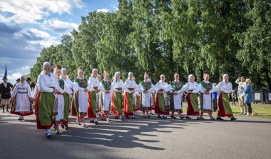 Tallinn, Estonya, 6 Temmuz 2019: Tallinn'de her 5 yılda bir düzenlenen 'laulupidu' şarkı festivali sırasında Pirita'daki şarkı festivali nde geleneksel estonya kıyafetleri içinde insanlar