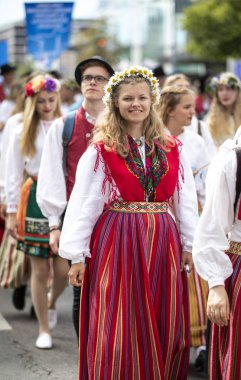 Tallinn, Estonia, 6th July, 2019: people in traditional estonian clothing in streets of Tallinn, walking to sing at song festival grounds at festival 'laulupidu'